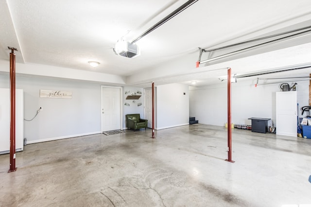 garage with a garage door opener and white fridge