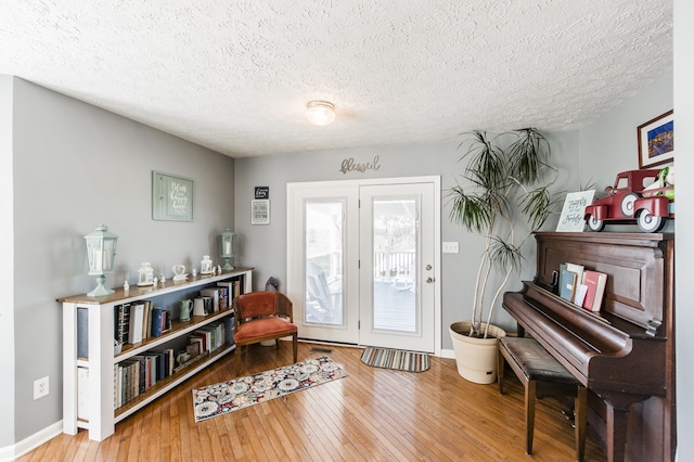 living area with wood-type flooring and a textured ceiling