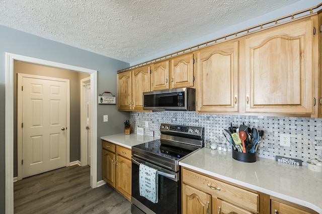 kitchen with a textured ceiling, appliances with stainless steel finishes, dark hardwood / wood-style flooring, and tasteful backsplash