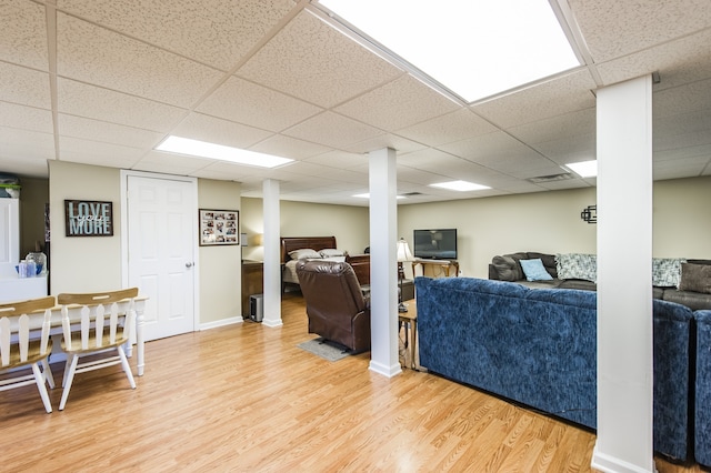 living room featuring wood-type flooring and a drop ceiling