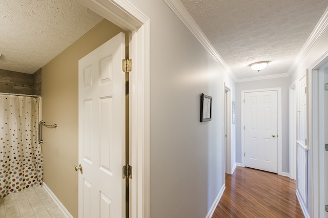 hall featuring a textured ceiling, crown molding, and hardwood / wood-style flooring