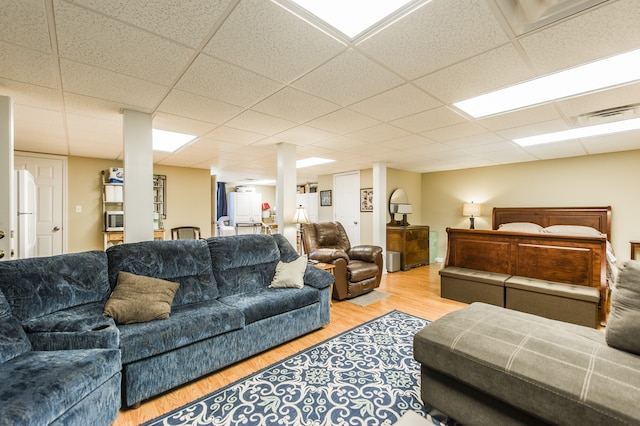 living room featuring light wood-type flooring and a drop ceiling