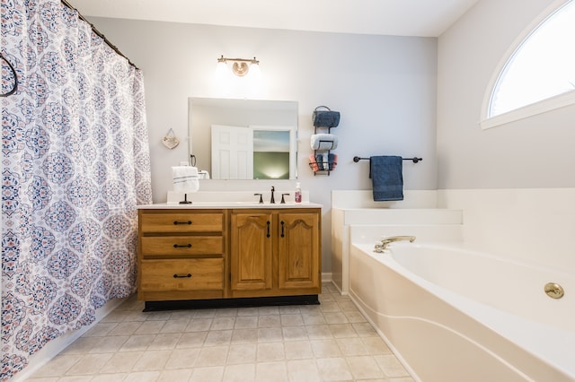 bathroom with a tub to relax in, vanity, and tile patterned floors