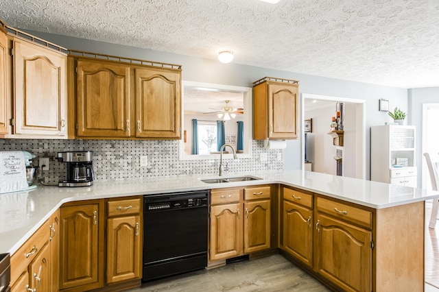 kitchen featuring sink, kitchen peninsula, tasteful backsplash, black dishwasher, and light hardwood / wood-style floors