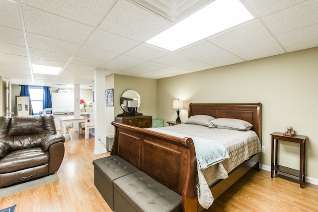 bedroom featuring light hardwood / wood-style flooring and a paneled ceiling