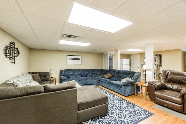 living room with wood-type flooring and a drop ceiling