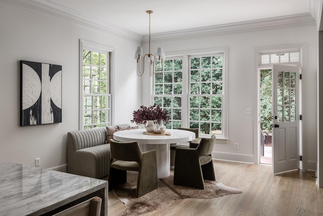 dining space featuring breakfast area, a chandelier, crown molding, and light hardwood / wood-style flooring