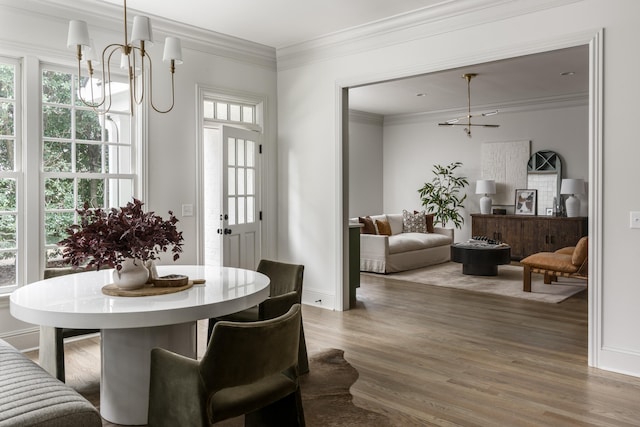 dining area featuring ornamental molding, a chandelier, and hardwood / wood-style flooring