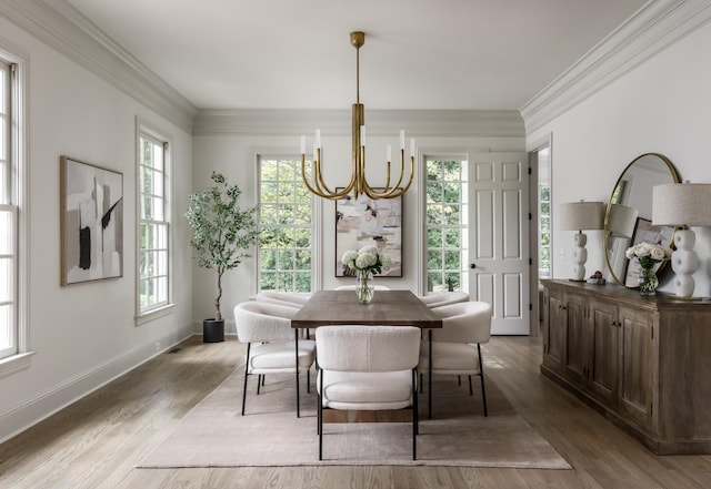 dining space featuring crown molding, hardwood / wood-style flooring, and a notable chandelier