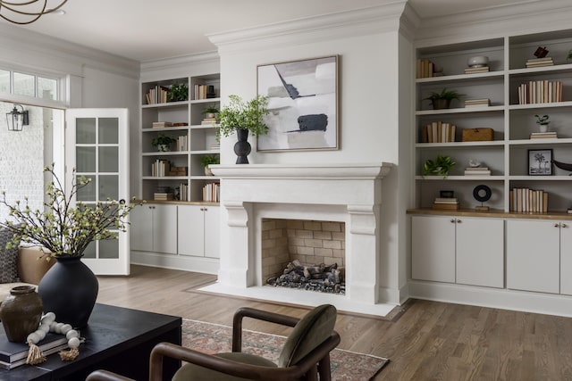 living room with built in features, dark hardwood / wood-style flooring, and ornamental molding