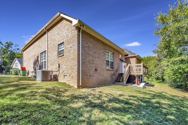 rear view of property featuring central AC unit, a deck, and a yard