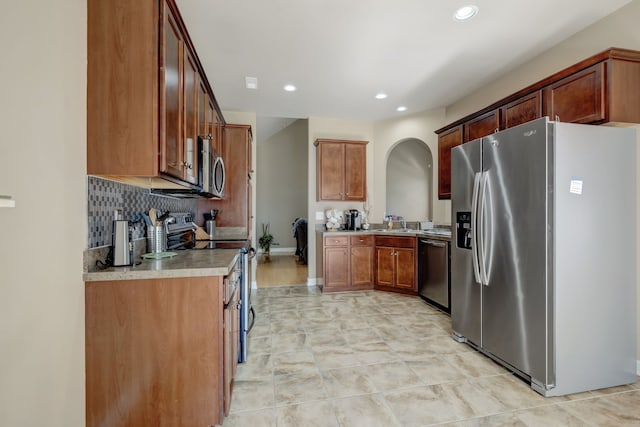 kitchen featuring decorative backsplash, light tile patterned flooring, appliances with stainless steel finishes, and sink