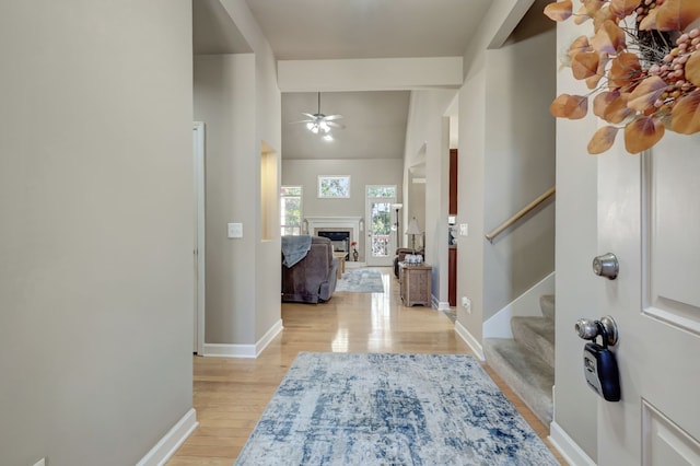 foyer entrance featuring ceiling fan, vaulted ceiling, and light hardwood / wood-style floors