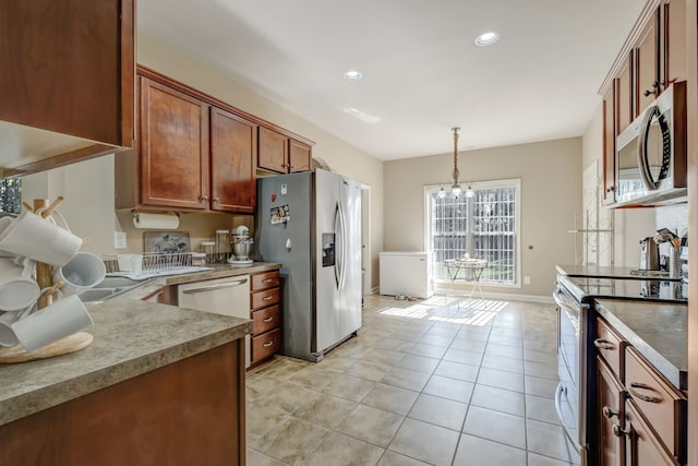 kitchen with stainless steel appliances, pendant lighting, a notable chandelier, and light tile patterned floors