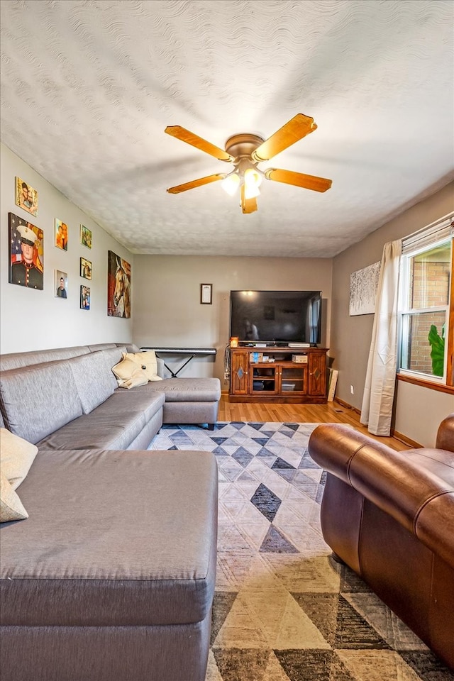 living room featuring ceiling fan, a textured ceiling, and hardwood / wood-style floors