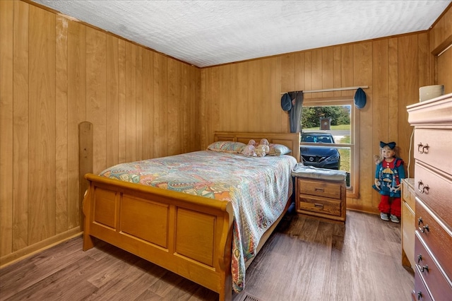 bedroom with hardwood / wood-style floors and wood walls