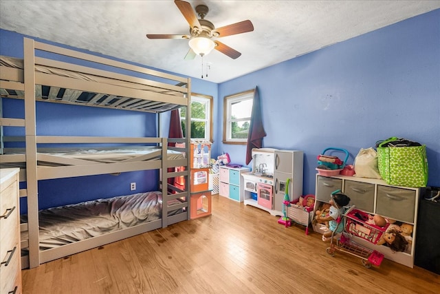 bedroom featuring hardwood / wood-style floors, a textured ceiling, and ceiling fan