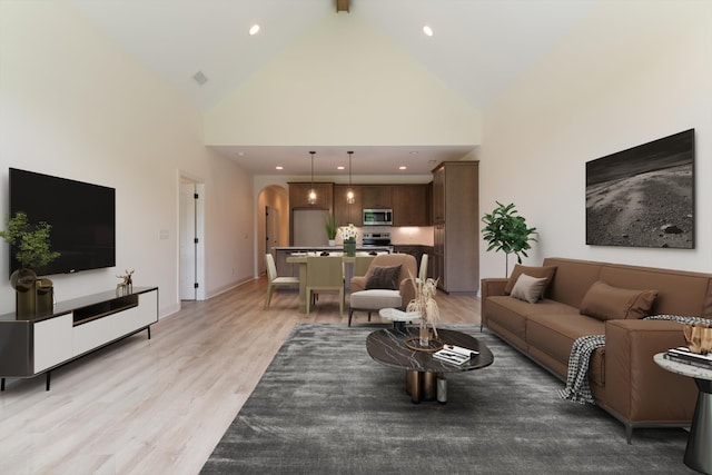 living room featuring light hardwood / wood-style flooring and high vaulted ceiling