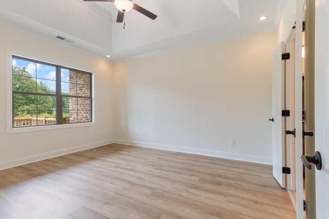 spare room with light hardwood / wood-style floors, a raised ceiling, ceiling fan, and crown molding