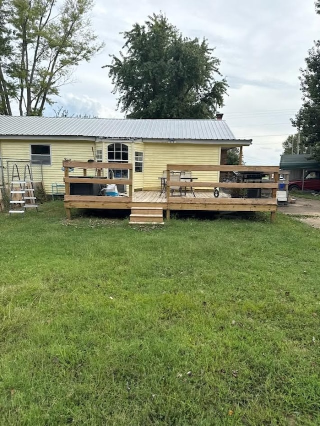 back of property with a wooden deck and a lawn