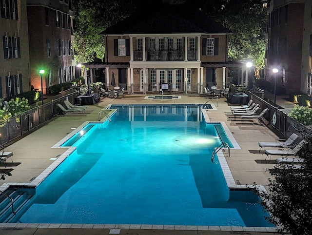 pool at twilight featuring a patio