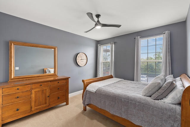 carpeted bedroom with ceiling fan and multiple windows