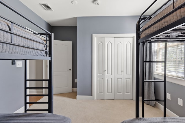 unfurnished bedroom featuring a closet and light colored carpet