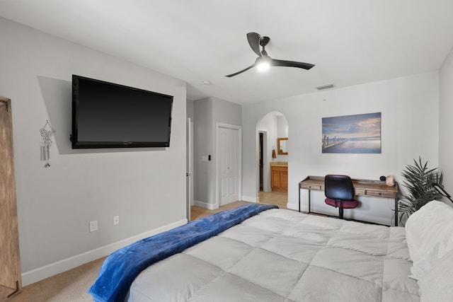 carpeted bedroom featuring connected bathroom and ceiling fan