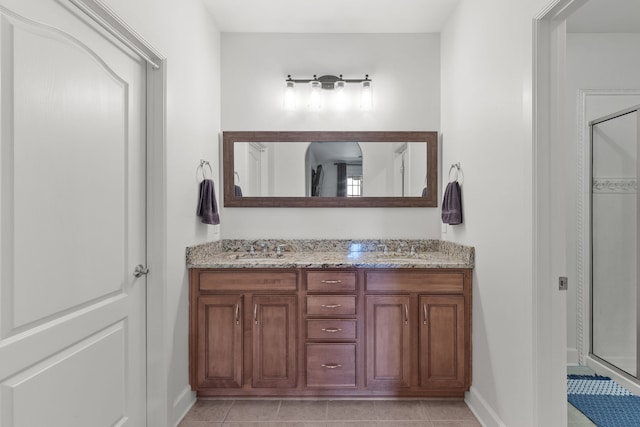 bathroom featuring tile patterned floors, a shower with shower door, and vanity