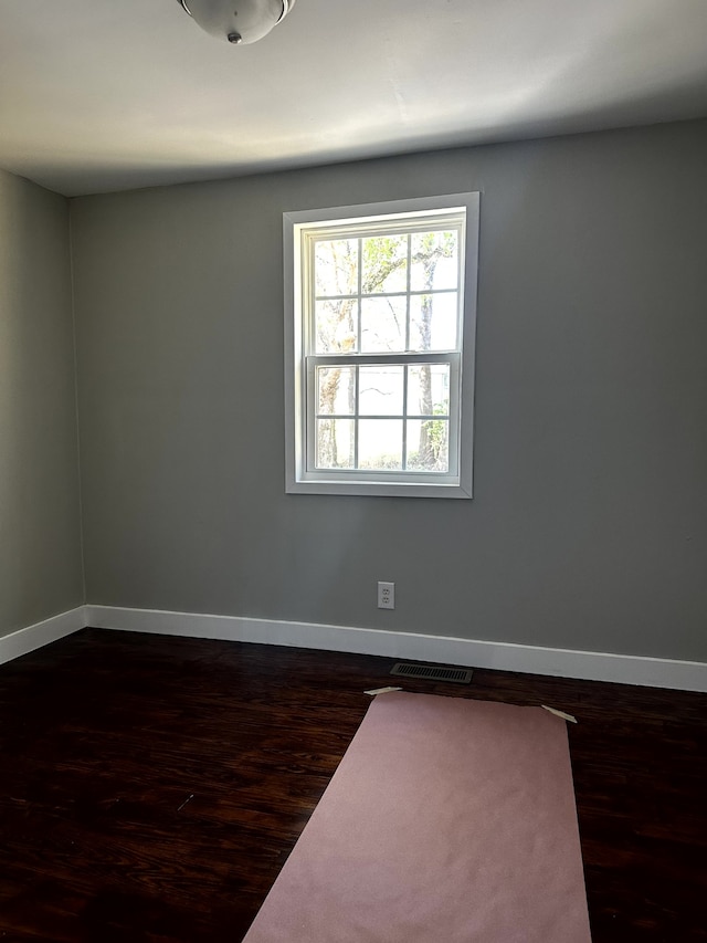 unfurnished room with dark wood-type flooring