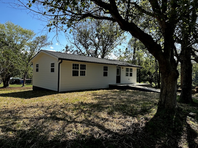 back of property with a lawn and a patio area