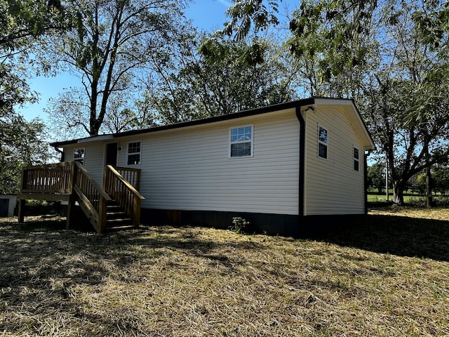 back of property featuring a deck and a yard