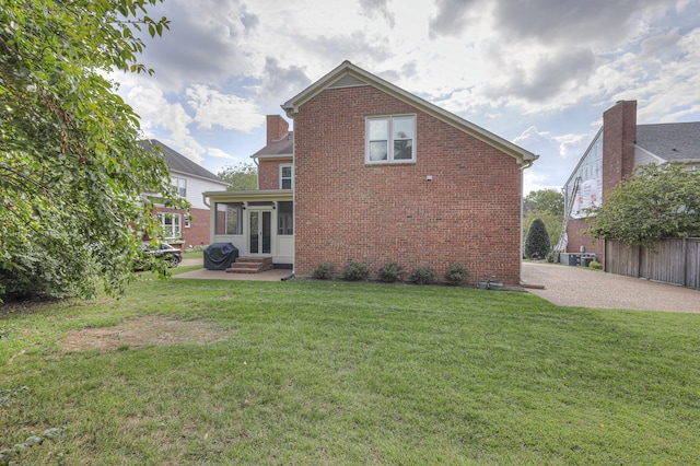 back of house featuring a patio area and a lawn