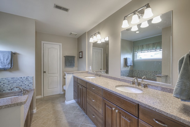 bathroom featuring tile patterned floors, vanity, toilet, and decorative backsplash