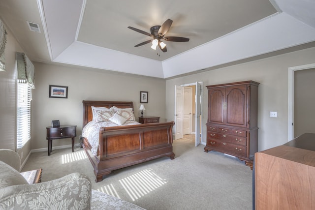 bedroom featuring light colored carpet, ceiling fan, and a raised ceiling