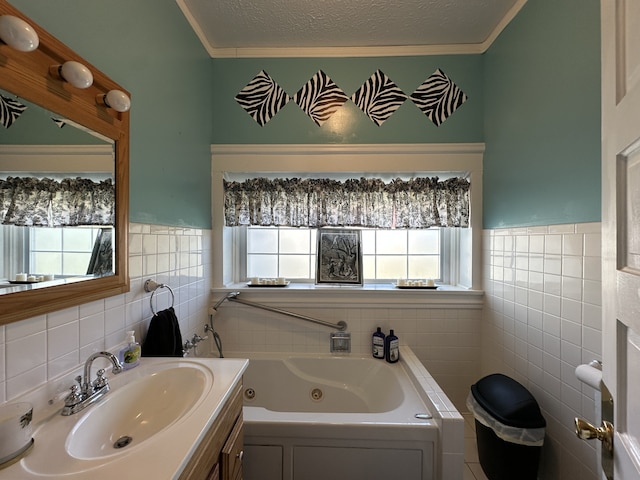 bathroom featuring tile walls, a textured ceiling, a bath, ornamental molding, and vanity