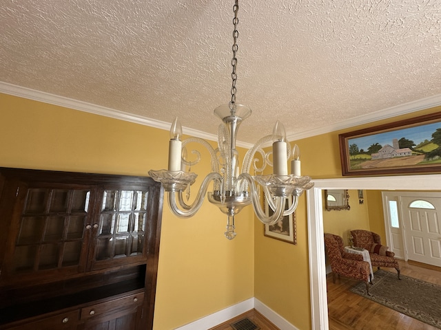 room details featuring hardwood / wood-style flooring, crown molding, a notable chandelier, and a textured ceiling