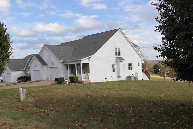 exterior space with a yard, central AC unit, and a garage