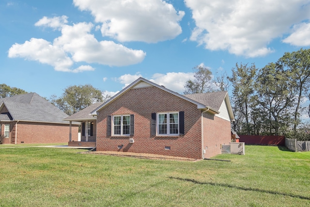 back of property with central AC unit and a yard