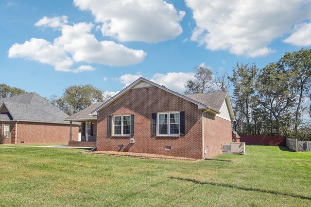 view of front of home featuring brick siding, a front yard, fence, and crawl space