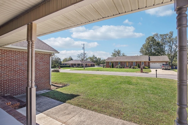 view of yard featuring concrete driveway and a garage