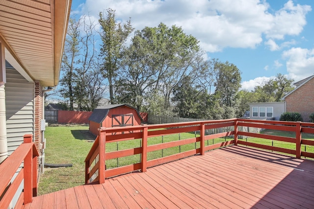 wooden terrace with a fenced backyard, an outdoor structure, a lawn, and a storage unit
