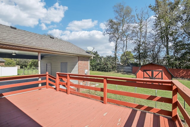 wooden terrace featuring a yard, a fenced backyard, a storage unit, and an outdoor structure