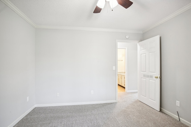 empty room featuring a textured ceiling, ceiling fan, ornamental molding, and light carpet