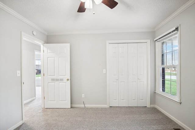 unfurnished bedroom featuring ceiling fan, light carpet, and a textured ceiling