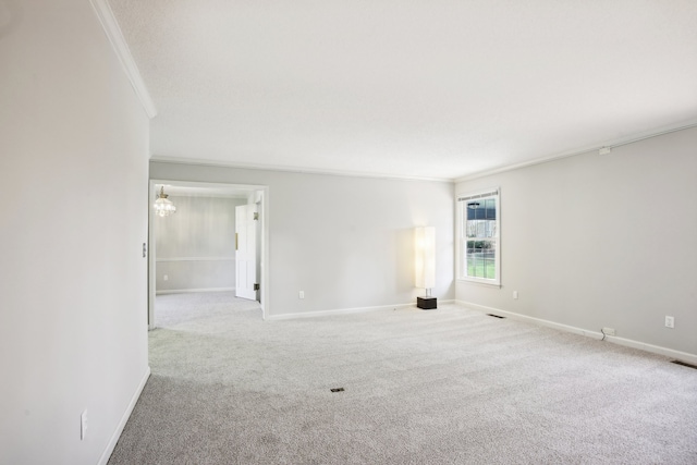 empty room featuring crown molding, light carpet, and a chandelier