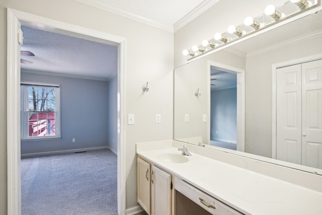 bathroom with a textured ceiling, vanity, and crown molding