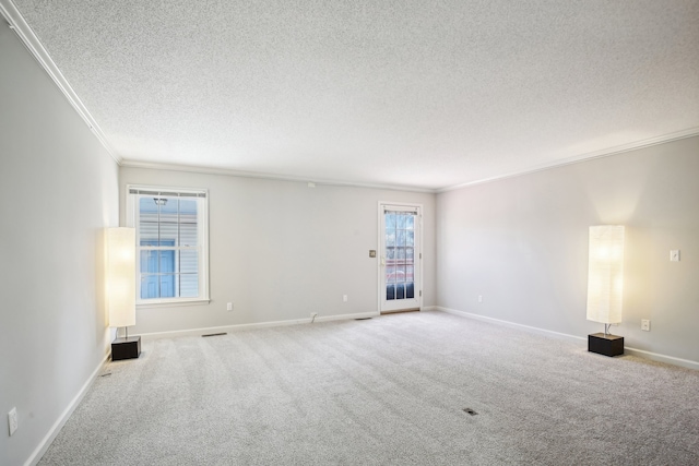 carpeted spare room with ornamental molding and a textured ceiling