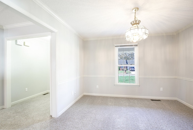 carpeted empty room featuring a notable chandelier, ornamental molding, and a textured ceiling