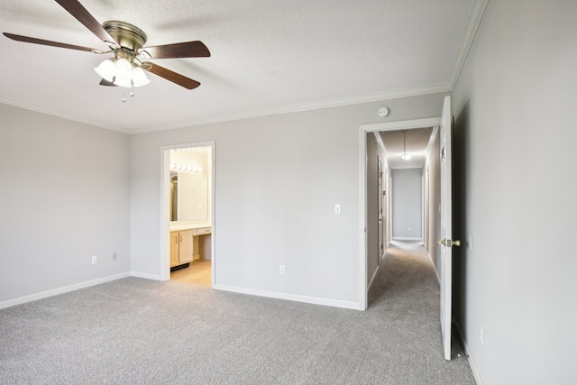 unfurnished bedroom with connected bathroom, light colored carpet, ceiling fan, and crown molding